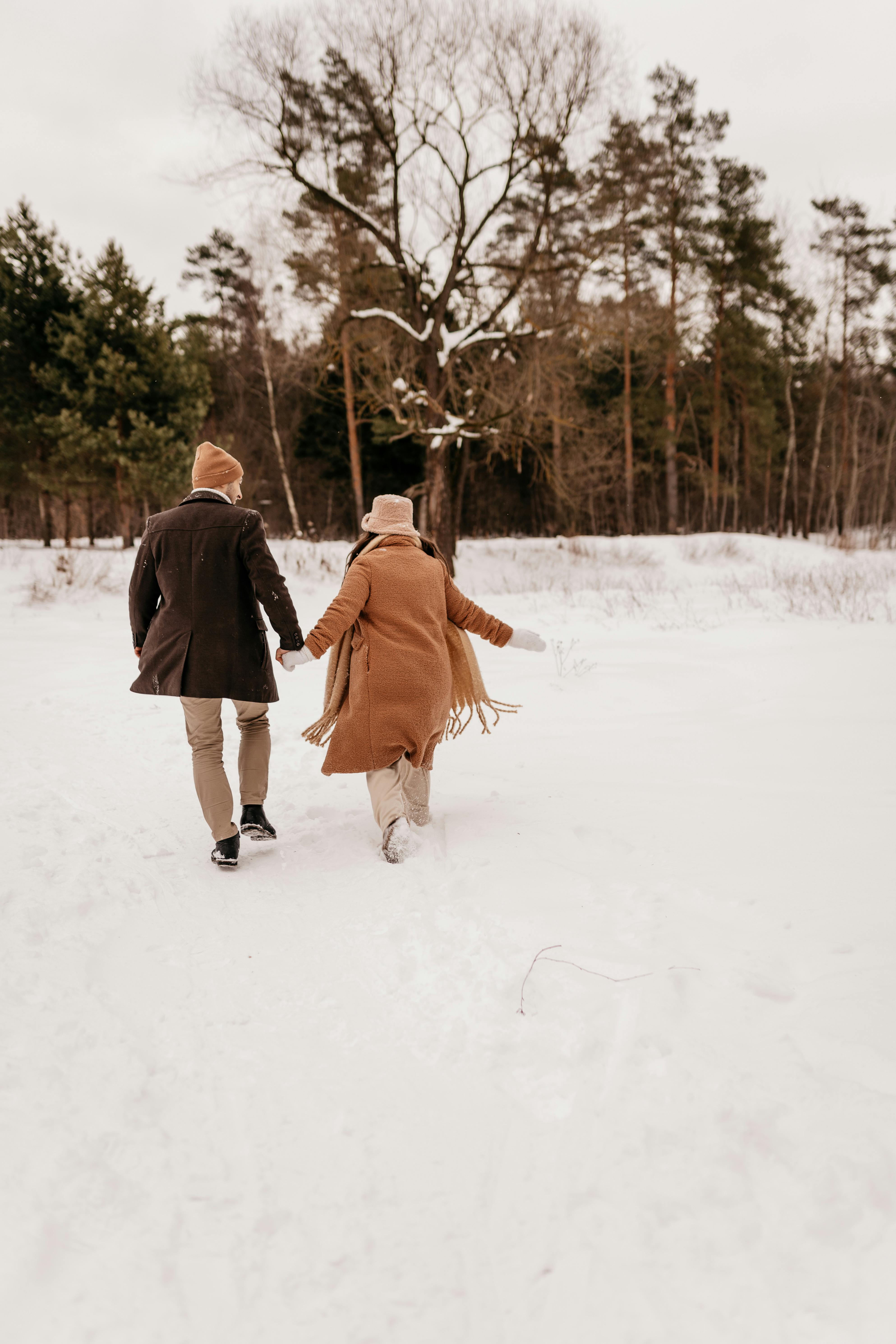 young couple running in the snow