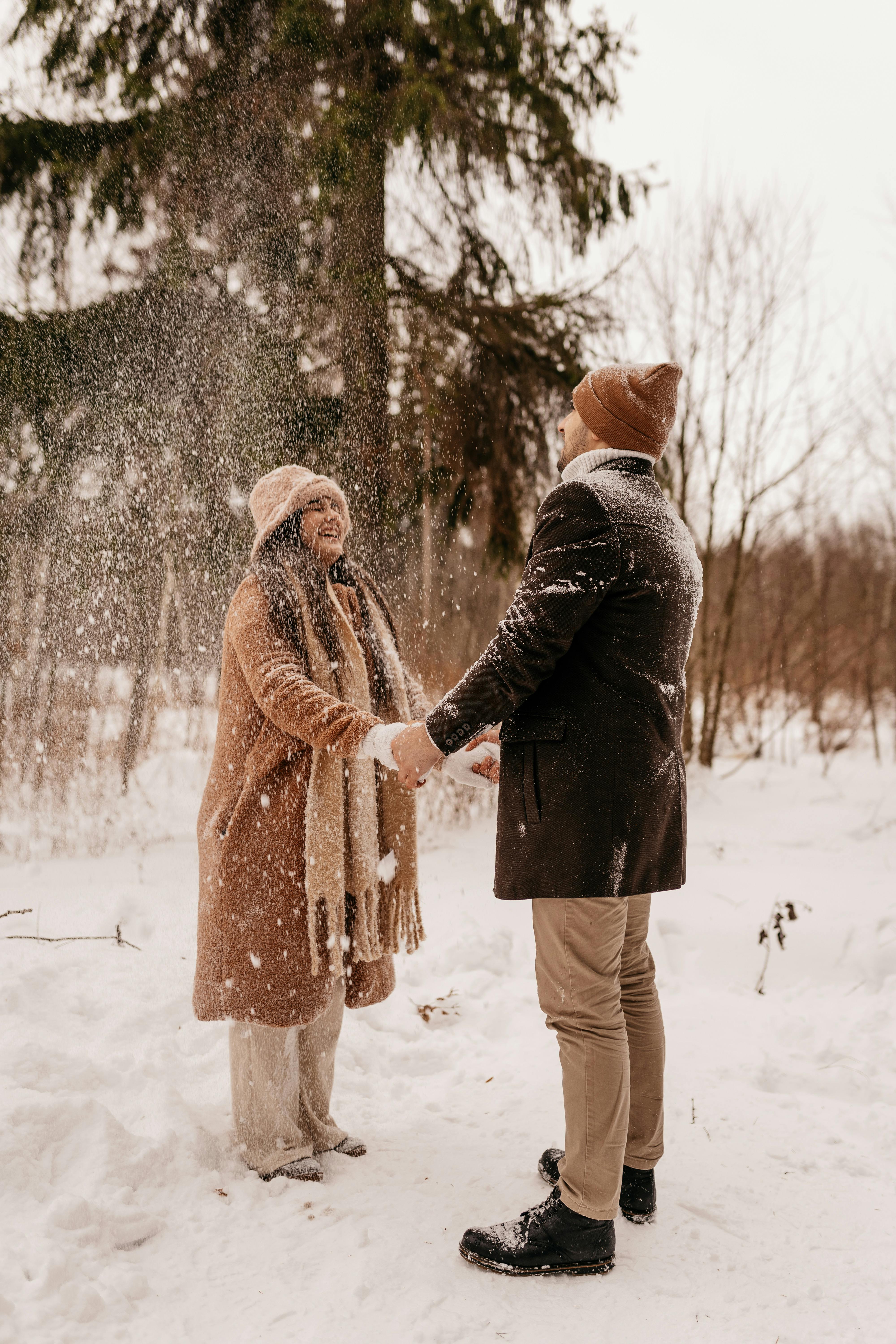 young couple holding hands in winter forrest