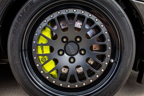 Free Detailed close-up of a car wheel featuring black alloy rims and visible brake caliper. Stock Photo