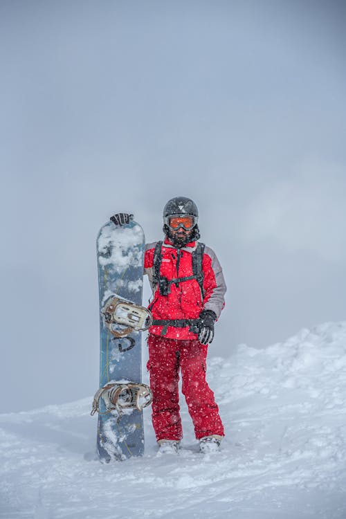 A Man Standing with a Snowboard