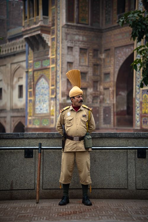 Free Guard in traditional uniform standing at Lahore's historical site, showcasing cultural heritage. Stock Photo