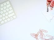 这个工作空间干净有序，配备了键盘和玫瑰金回别针，非常适合激发设计灵感