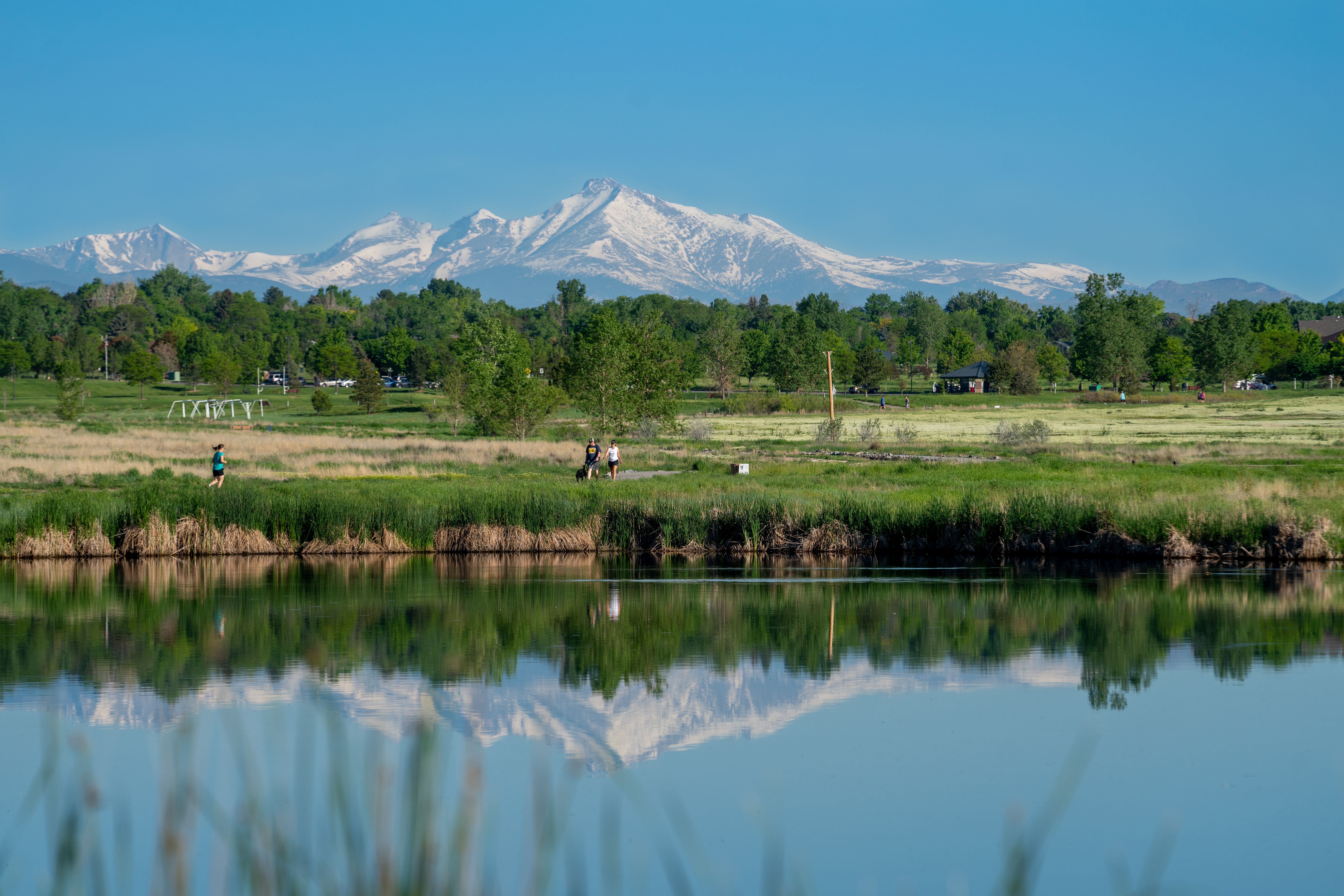 Beautiful landscape of mountains reflecting on a serene lake surrounded by lush greenery.