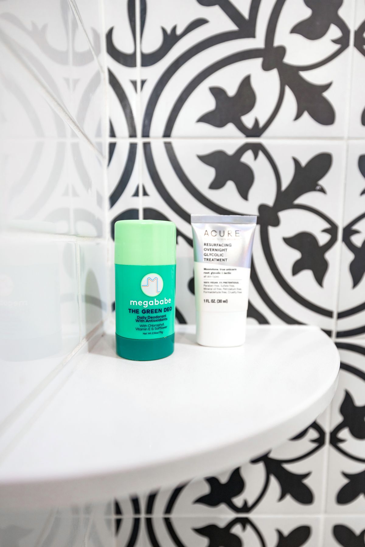Skincare products and toiletries organized in neat rows on a stylish bathroom shelf against a tiled wall