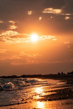 A mesmerizing golden sunset casts warm light over a tranquil ocean shore.