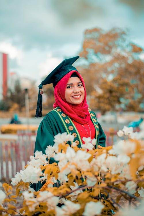 Smiling Lady with Red Hijab Wearing Graduation Gown 
