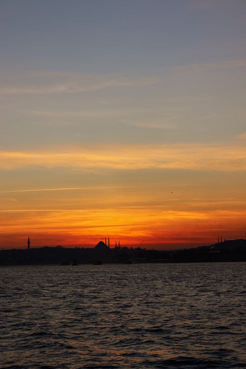 Free A stunning sunset over the sea with a vibrant and dramatic sky, capturing the perfect tranquil moment. Stock Photo
