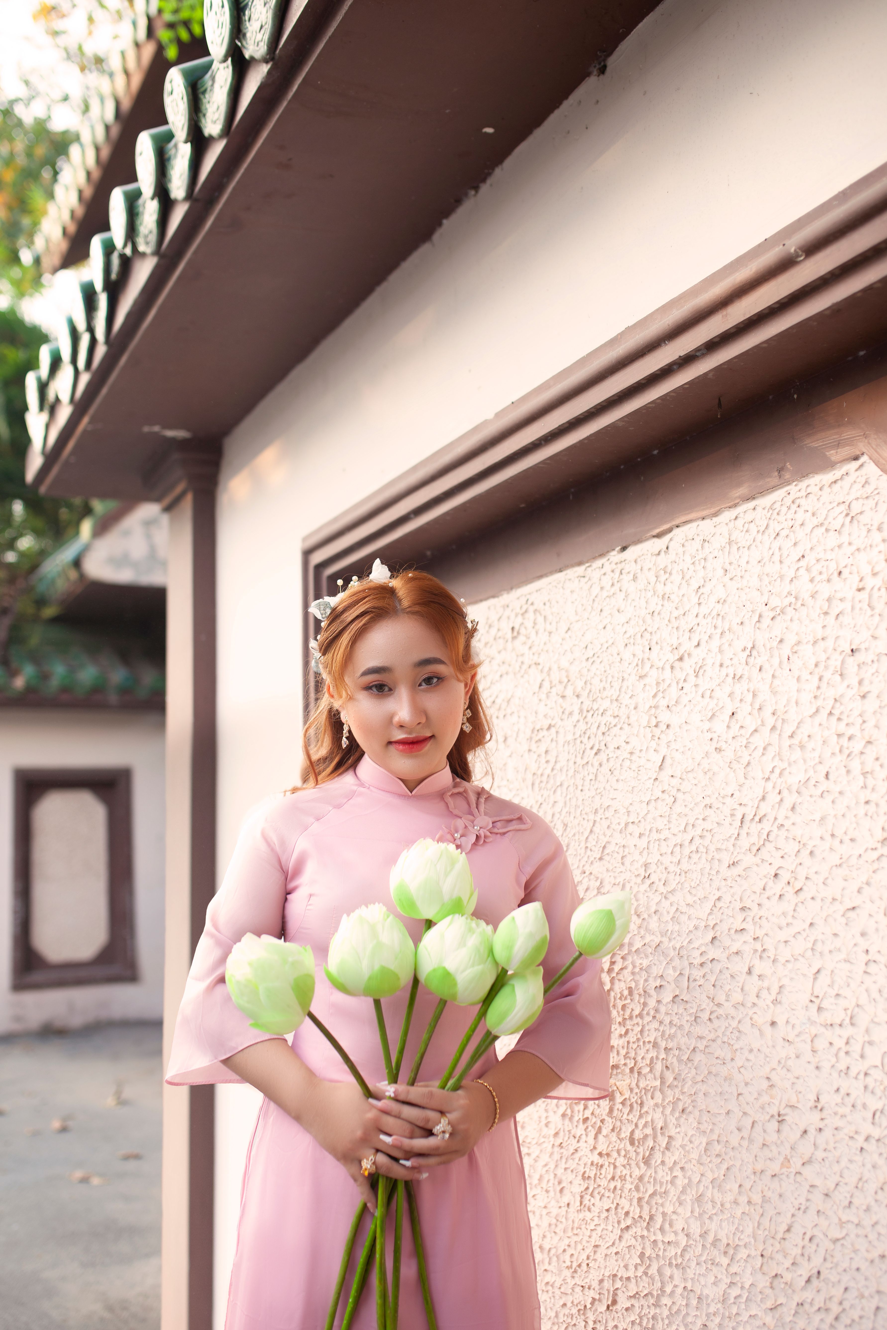 A Woman in Pink Dress Holding Green and White Flowers · Free Stock Photo