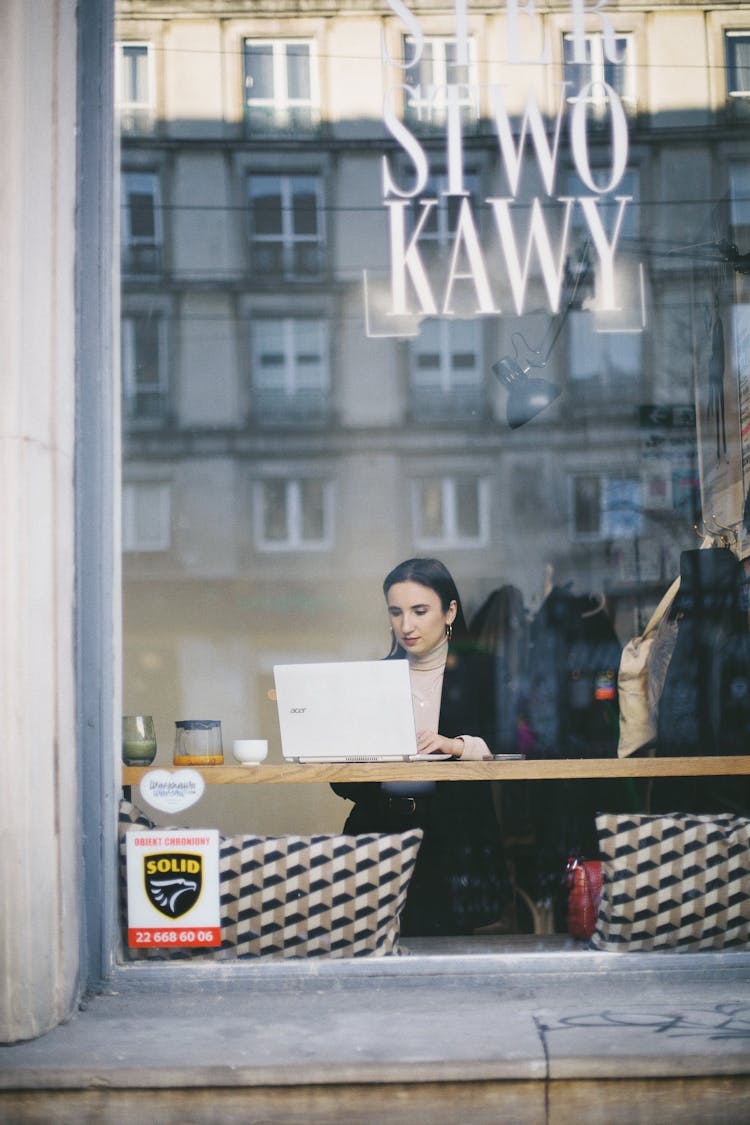 Woman Working On Laptop In Cafe