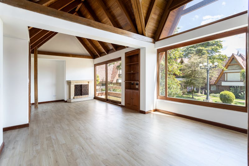 Bright and spacious empty interior of a newly built modern house with large windows and wooden ceiling