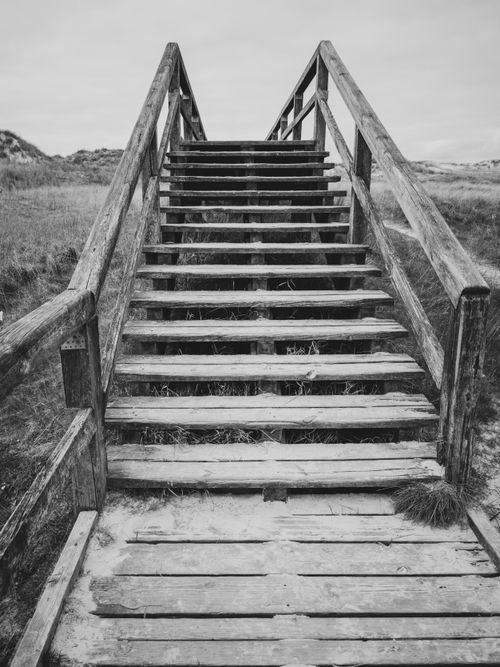 Free Black and white image of a rustic wooden staircase in an outdoor setting. Stock Photo
