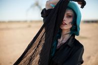 Woman in Black Coat Covering Her Face With Brown Scarf