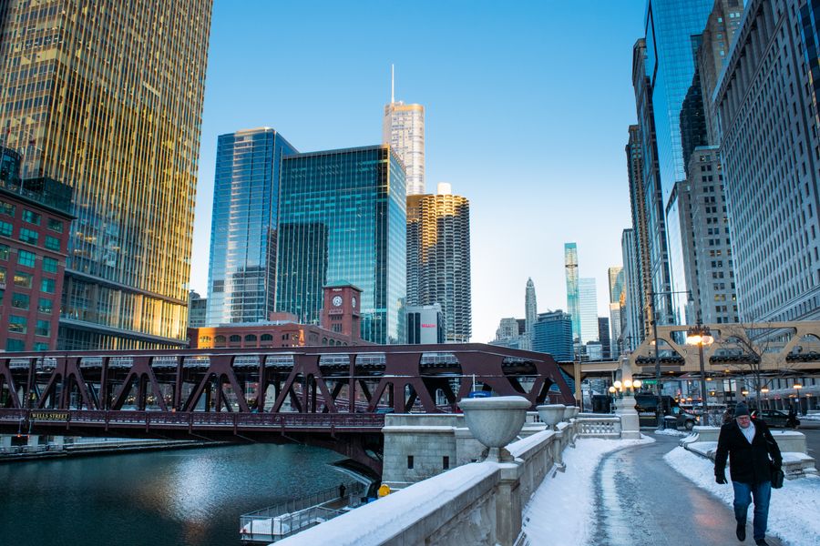 Downtown Chicago in winter with snow on the ground, a bridge and skyscrapers