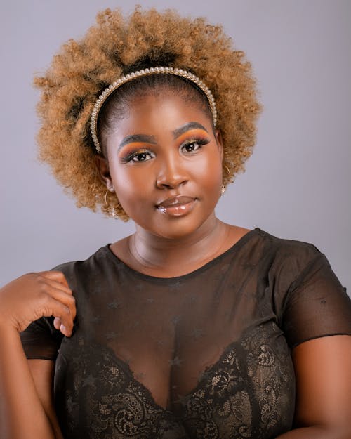 Woman in Lace Blouse Posing with Hand on Shoulder