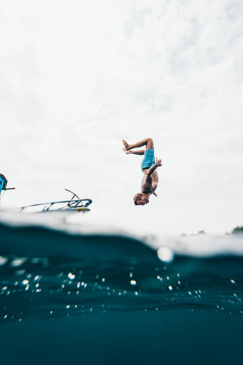 Free Man Wearing Blue Shorts About to Dive on Body of Water Stock Photo