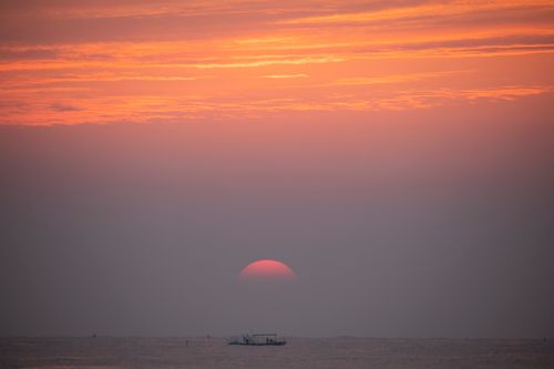 Free A tranquil sunset over the sea with a boat silhouette, capturing the serene beauty of Yangyang's coastline. Stock Photo