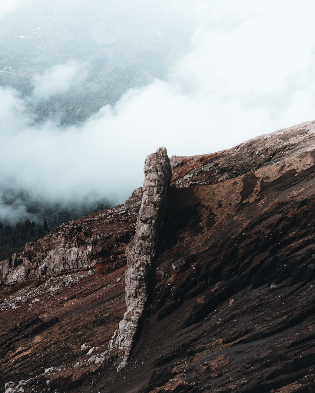 Eroded rock formation amidst foggy Indonesian landscape, perfect for travel and nature scenes.