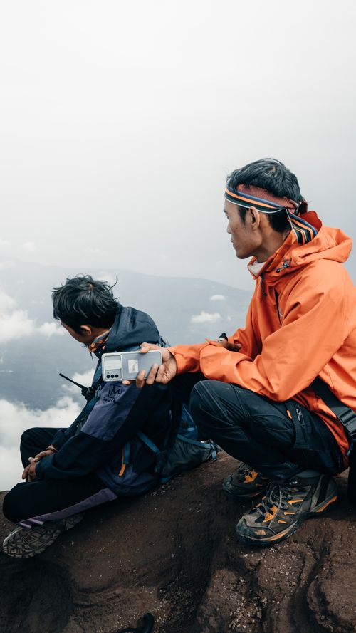 Free Two men enjoying a mountain view in Indonesia, capturing memories with a camera. Stock Photo