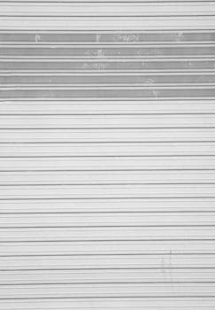 A minimalistic image of a metallic rolling shutter, suitable for industrial themes.