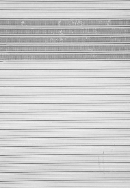 A minimalistic image of a metallic rolling shutter, suitable for industrial themes.
