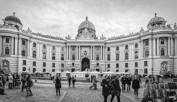 Black and white photo of the historic Hofburg Palace with people in Vienna, Austria.