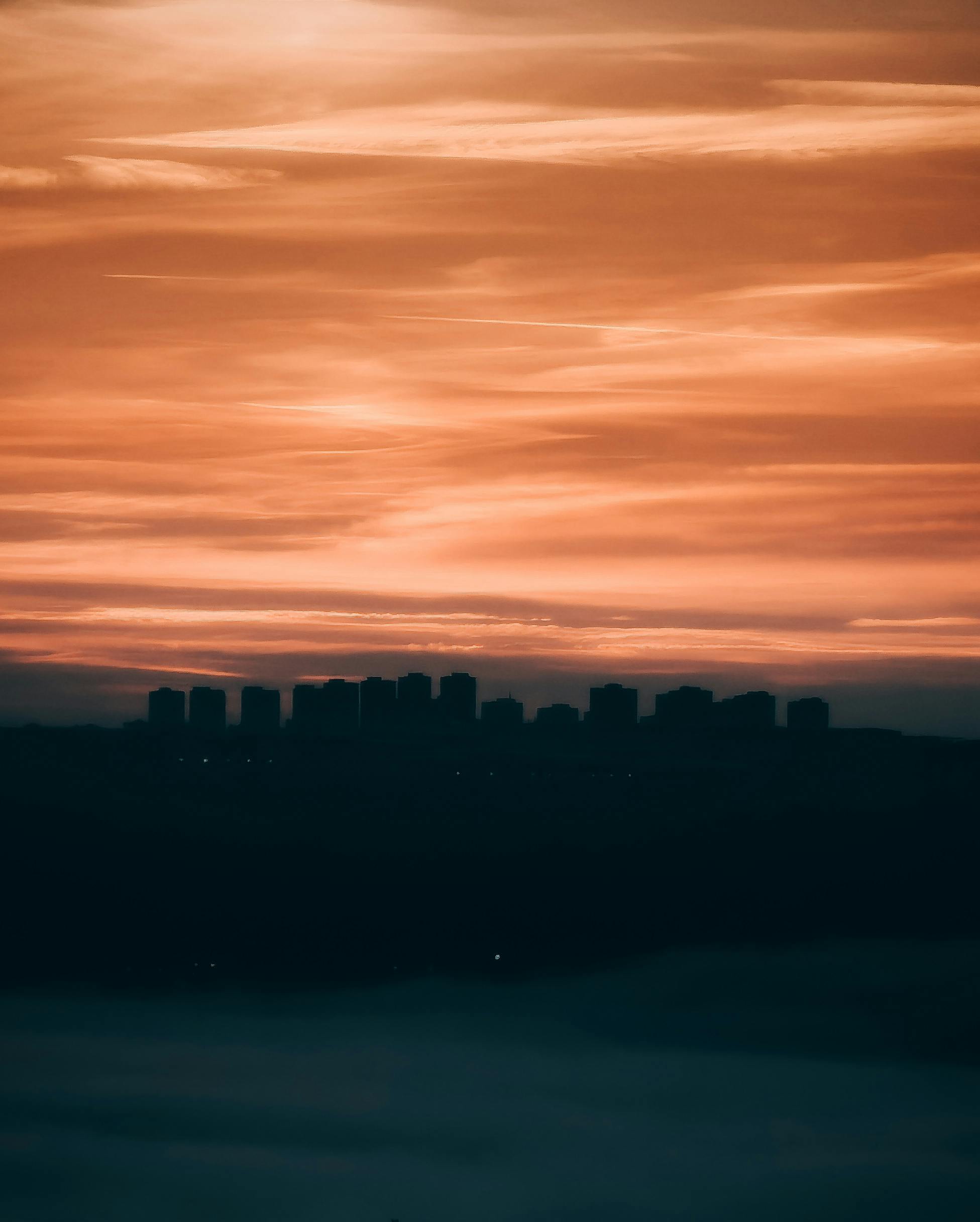 A captivating silhouette of an urban skyline against a dramatic golden hour sky.
