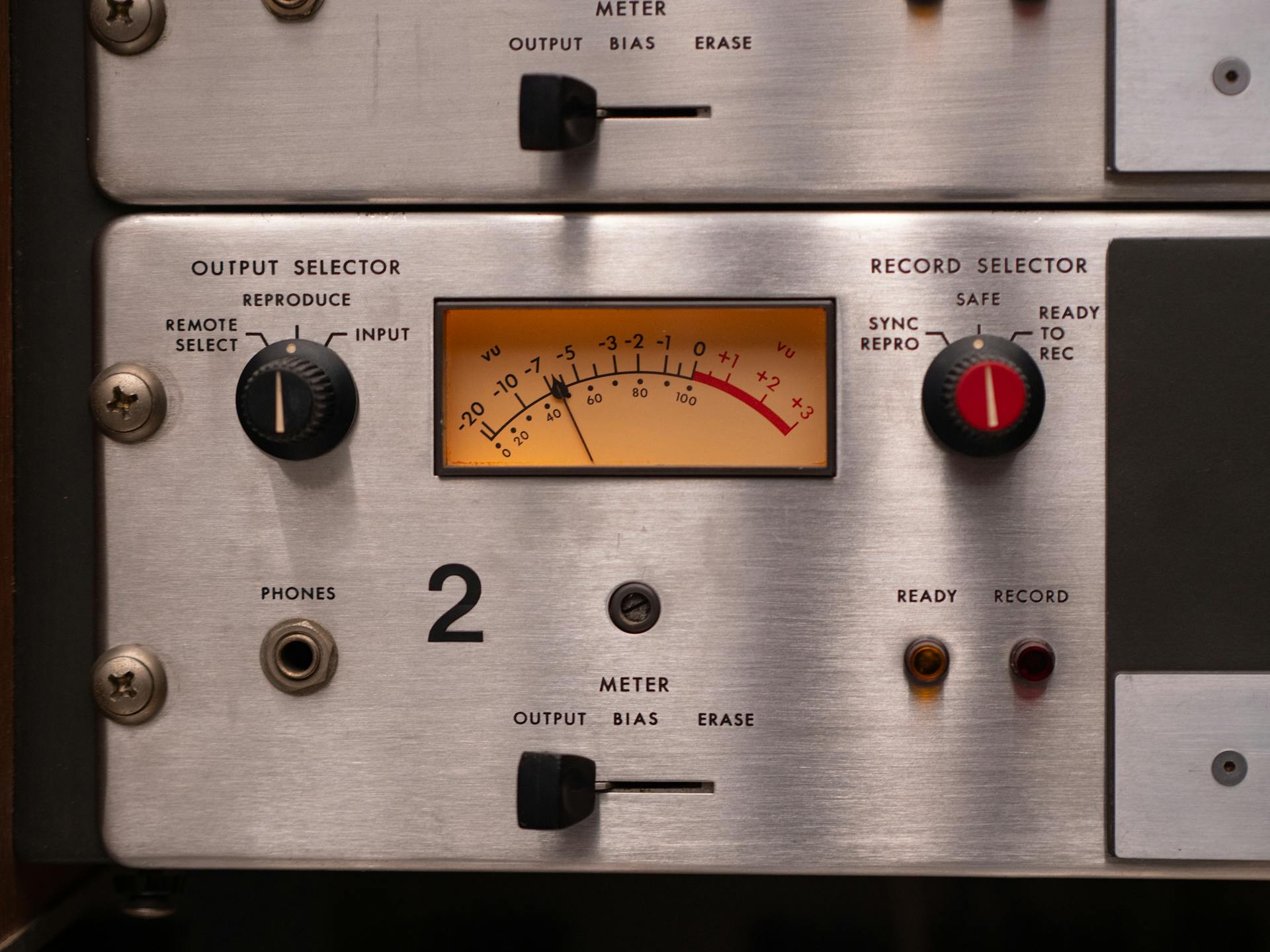 Detailed view of a vintage audio panel with dials and VU meter for recording settings.