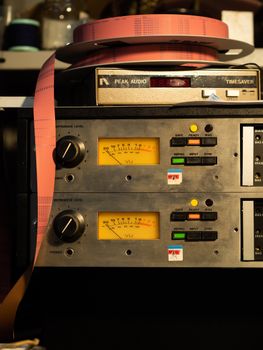 Close-up of vintage audio equipment with tape reel and VU meters, highlighting analog technology.