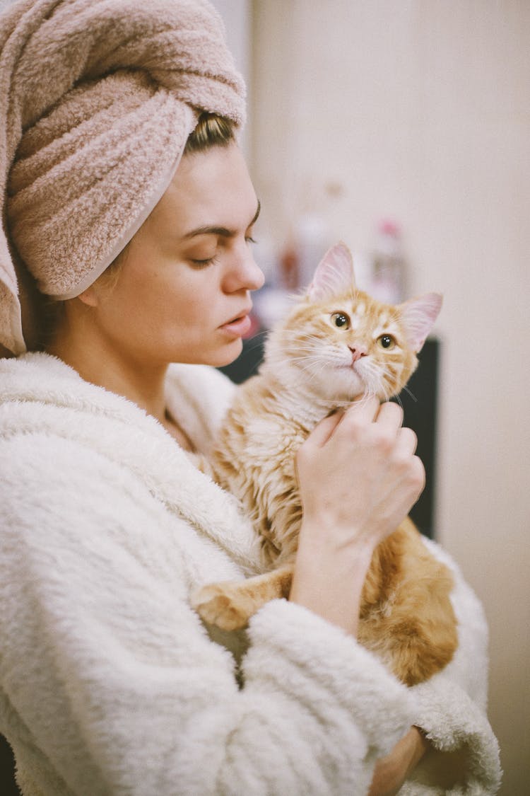 Woman With Hair Wrapped In Towel Holding Cat