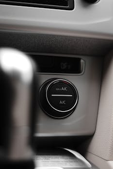 Vertical close-up shot of a car air conditioning control dial, highlighting the dashboard interface.