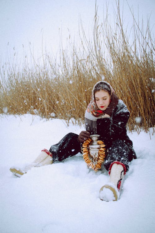 Free Girl in Black Jacket Sitting on Snow Covered Ground Stock Photo