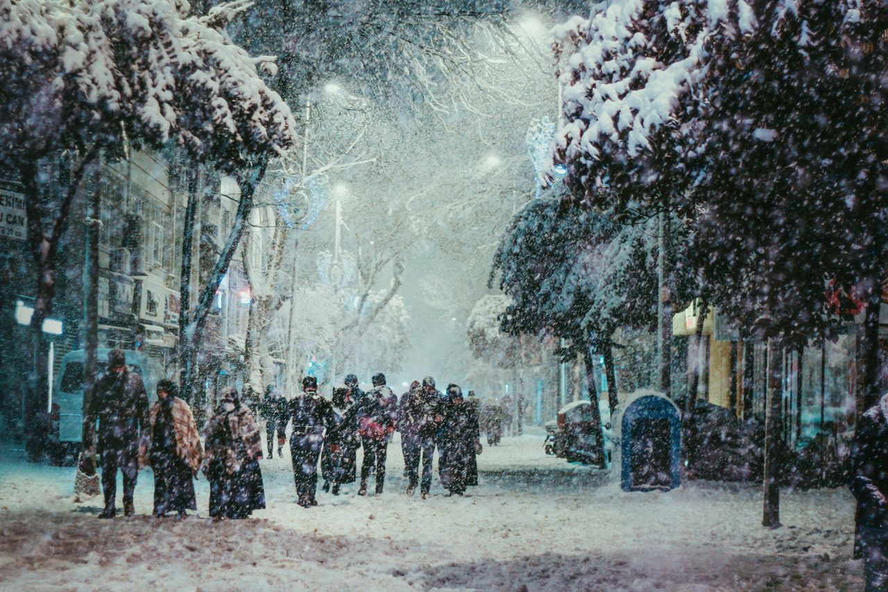 Crowd walking down a snowy city street