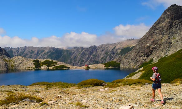 徒步旅行者在风景如画的山湖边，迎着晴朗的天空，享受宁静的散步