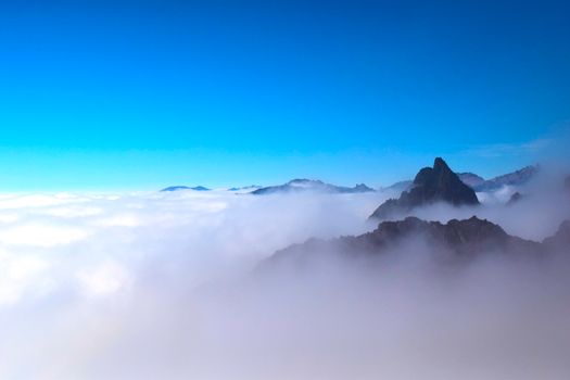 晴朗的日子里，山峰穿过云层的景象令人惊叹