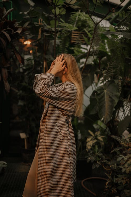 Woman in checkered Coat Fixing Her Hair