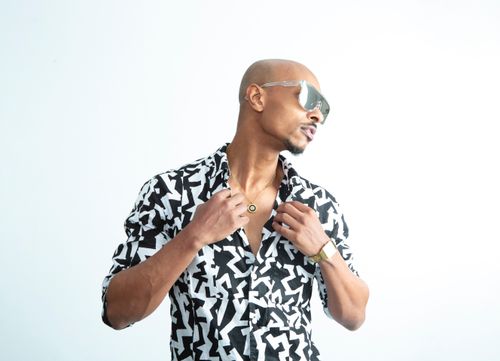 Free A stylish man with sunglasses poses in a modern shirt against a white background, exuding confidence. Stock Photo