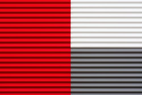 Free Close-up of red, white, and gray corrugated metal sheets forming a geometric pattern. Stock Photo