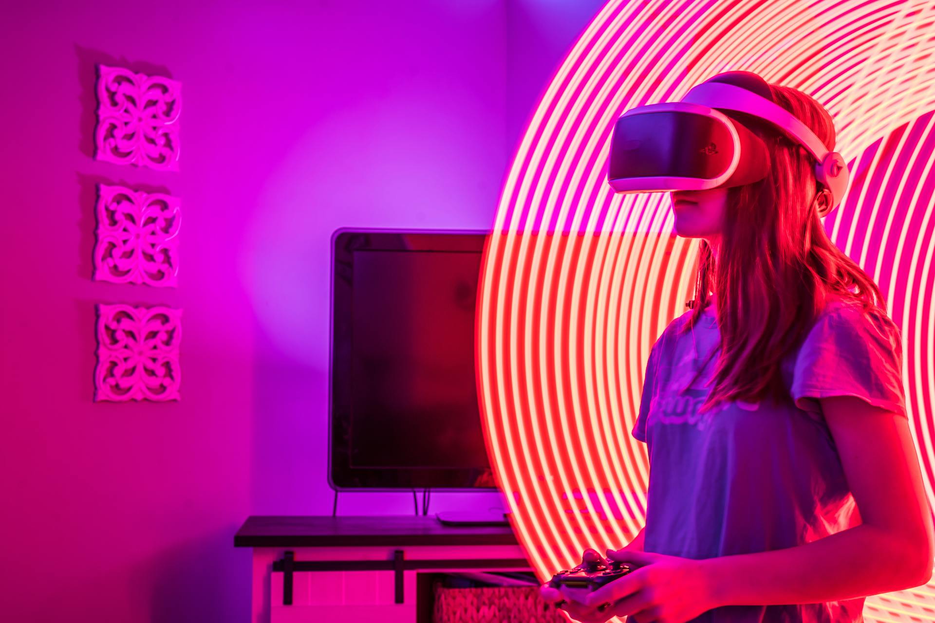 A woman experiences virtual reality gaming indoors, surrounded by vibrant neon lighting.