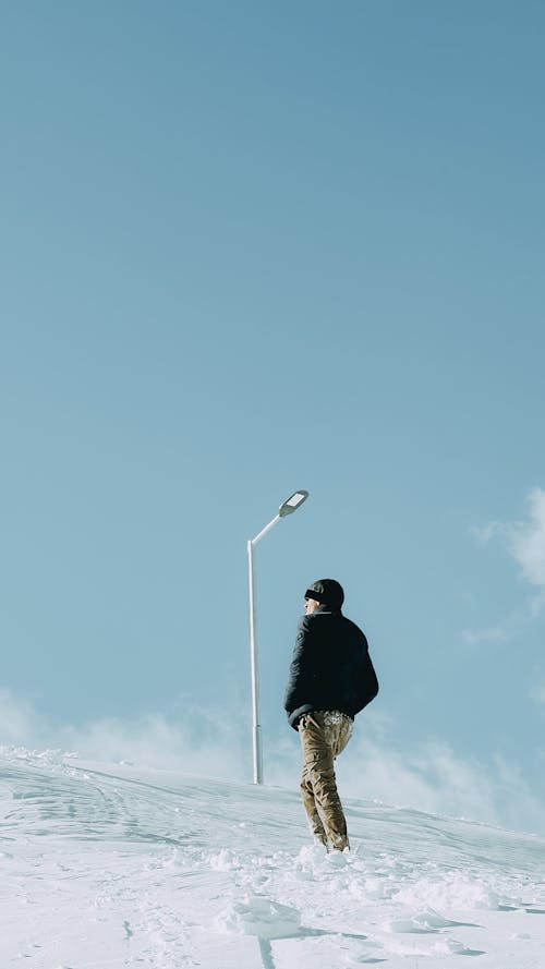 A Man Walking on Snow Covered Ground