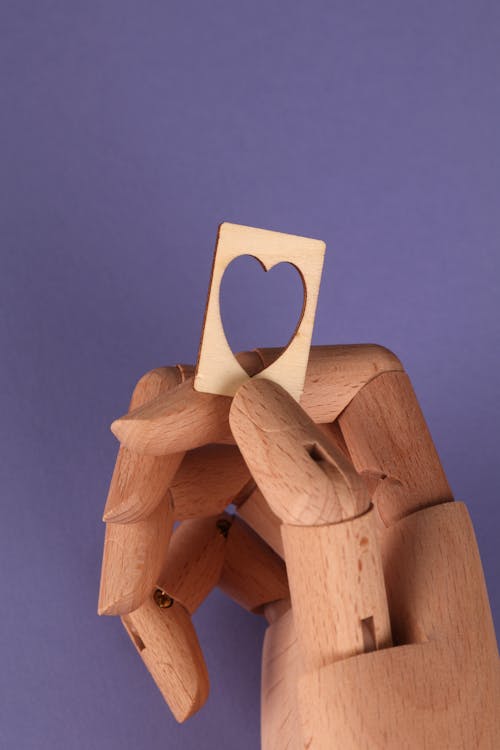 Brown Wooden Action Figure Holding Heart Shaped Wood