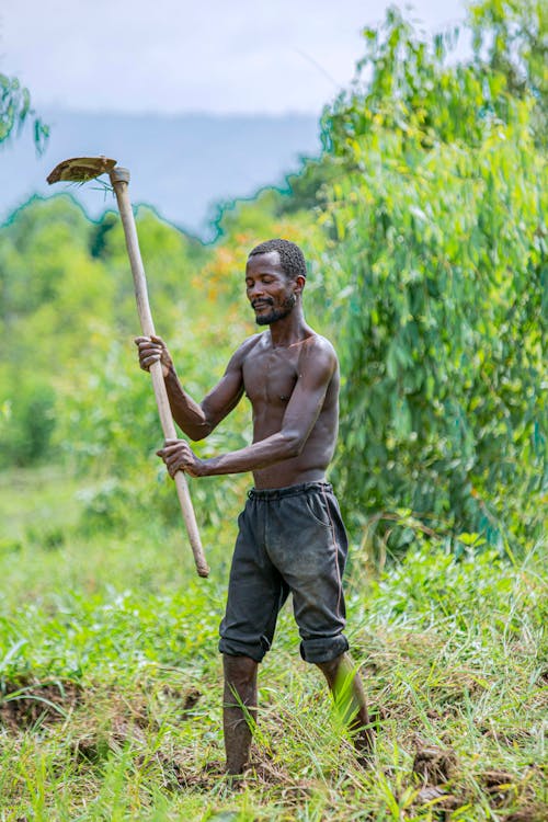Topless Man holding a Hoe 