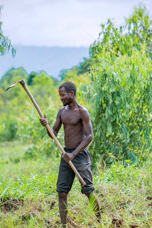 Topless Man holding a Hoe