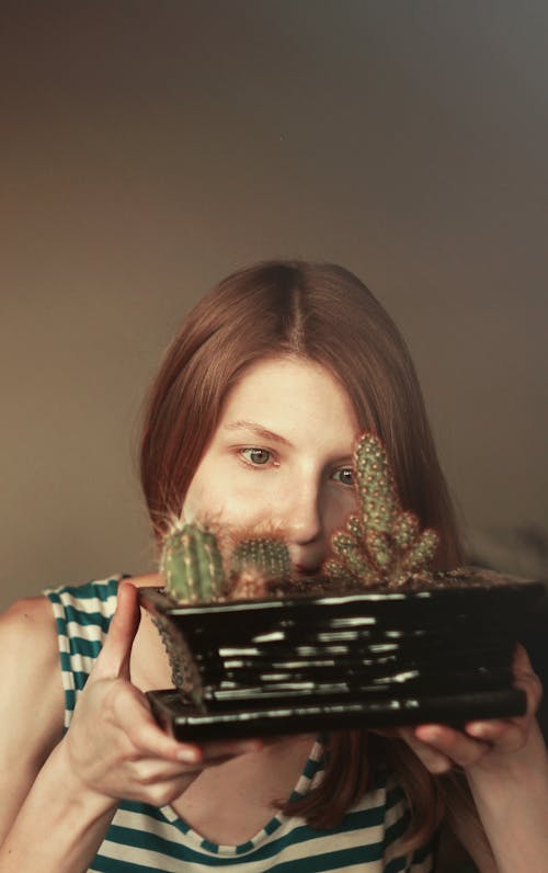 Woman Looking Closely to Cactus on Plant Pot
