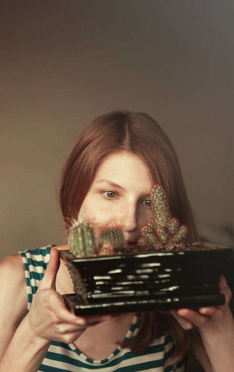 Gratuit Femme à La Recherche De Près De Cactus Sur Pot De Plantes Photos