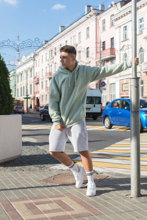A Man in Green Hoodie Standing on the Street