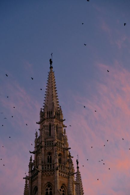 A picturesque view of the Matthias Church steeple against a vibrant sunset in Budapest, Hungary.