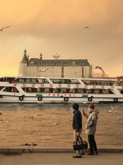 Men Taking Pictures of Seagulls Flying around Turyol Ferries in Istanbul