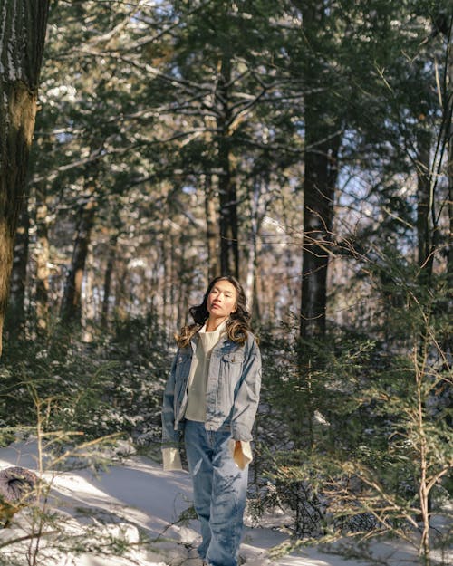 Free Woman in Jean Jacket Standing in Forest Stock Photo