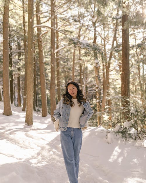 Free Woman in Jean Jacket Standing in Winter Forest Stock Photo