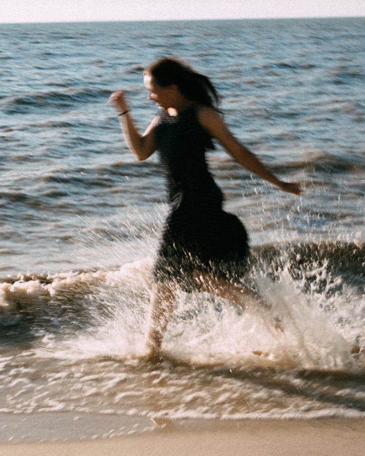 A Woman Running At The Beach 